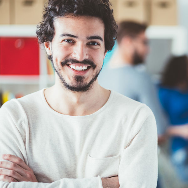 man smiling with arms crossed